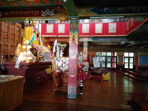 The view from a side of the gompa. The seat of the teacher, the white board and the books (sutras) behind the Lama Tsongkhapa statue are visible.