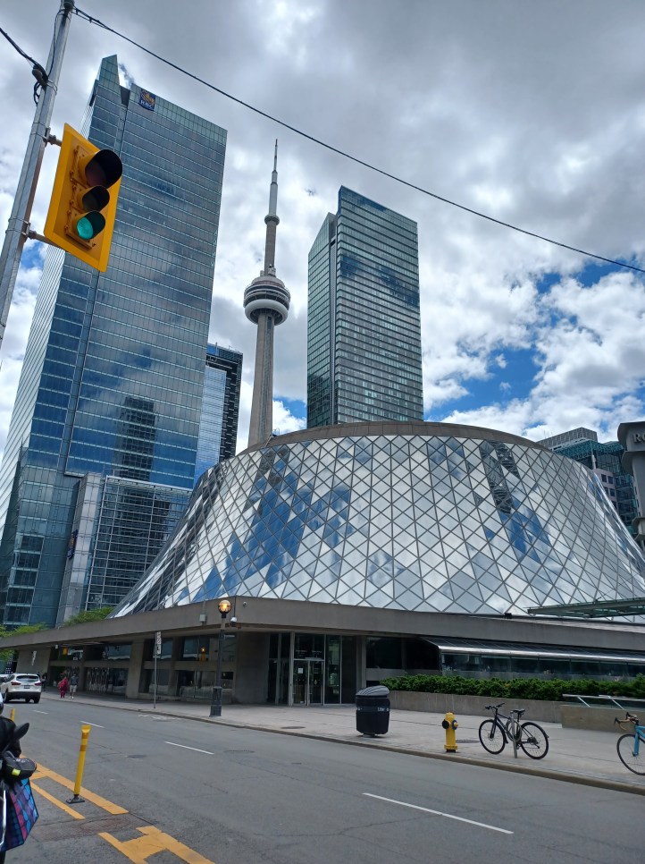The curved building is the Roy Thomson Hall - the home of the Toronto Symphony Orchestra. It is a multipurpose hall and also acts as one of the venues of TIFF.